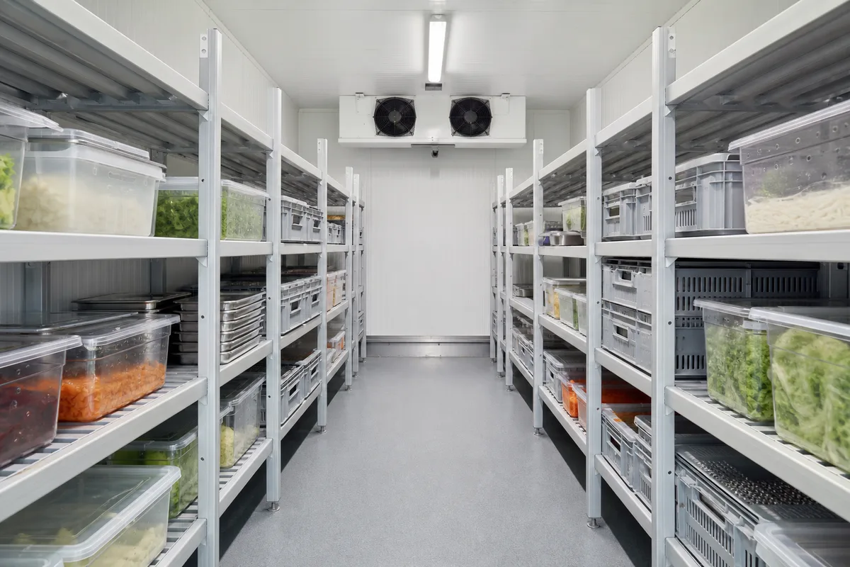 Rayonnages en aluminium chargés de bacs de viande dans une chambre froide professionnelle